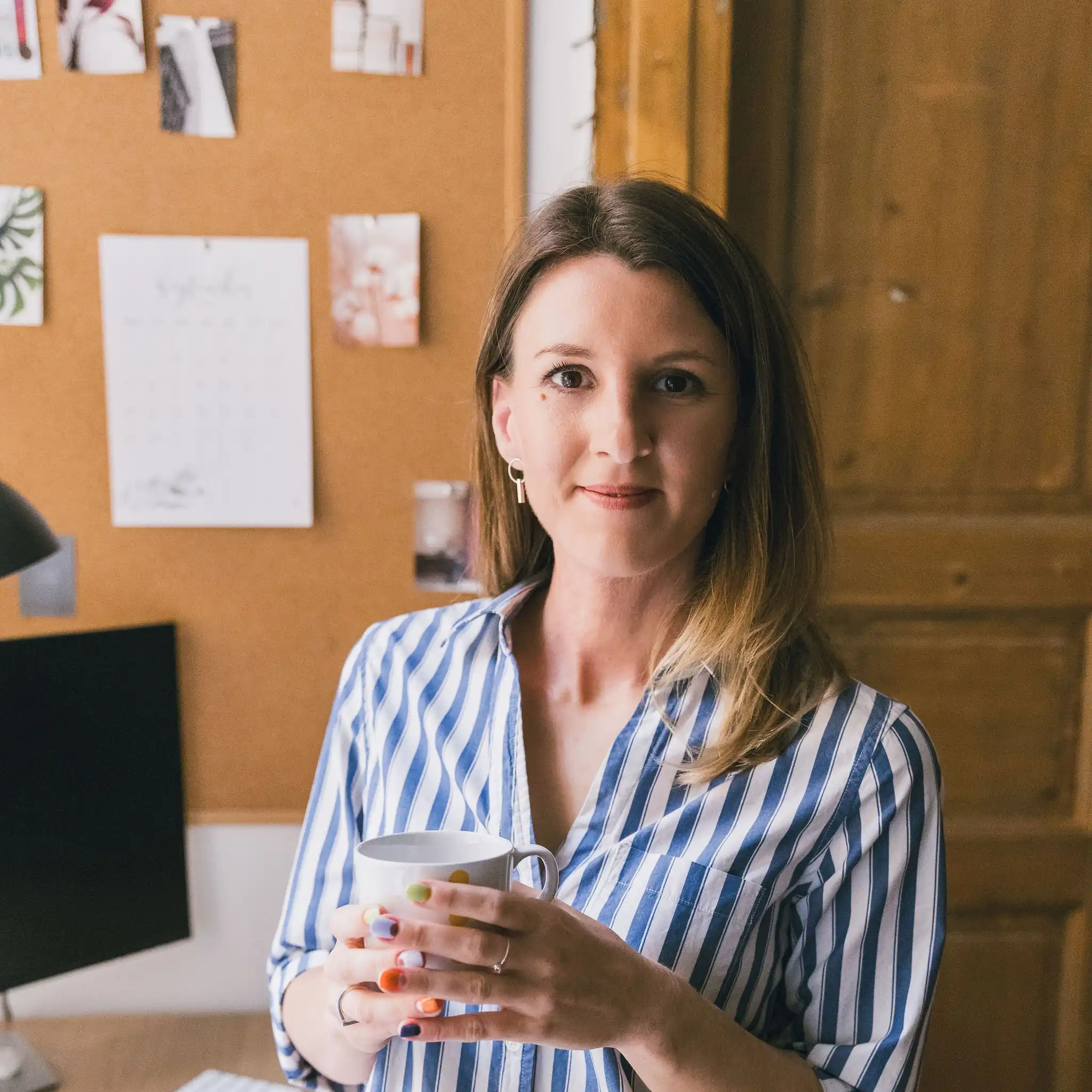 Kamilla, a MathSisters matektanárnője bögrével a kezében az íróasztalánál
